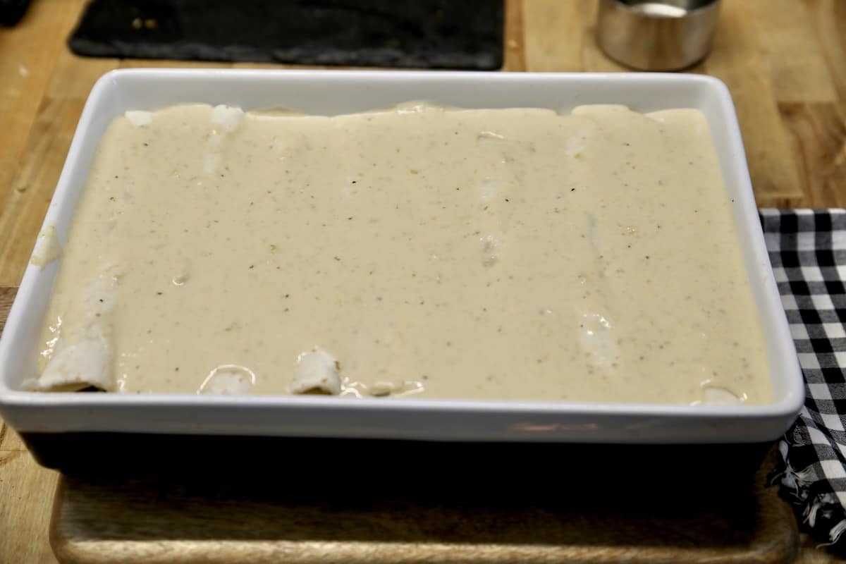 Salsa verde enchiladas. Pan of enchiladas with salsa verde sauce, ready to bake.