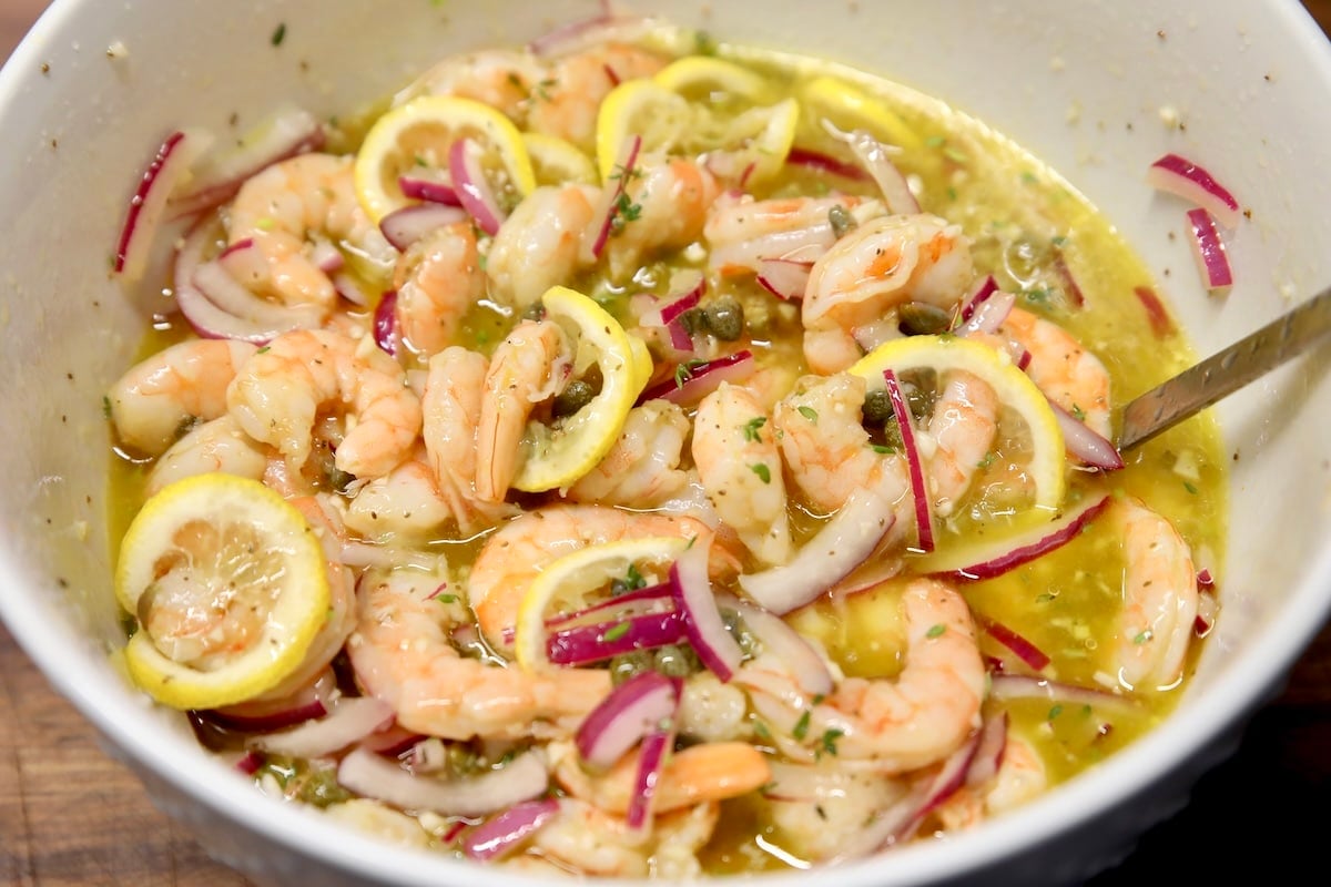 Bowl of shrimp, onion and lemons in brine.