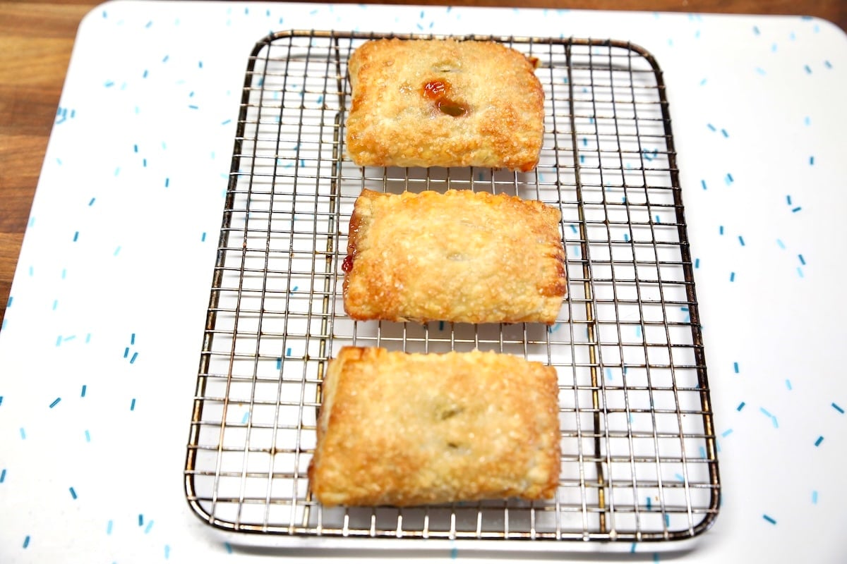 3 Puff pastry strudels on a wire rack.
