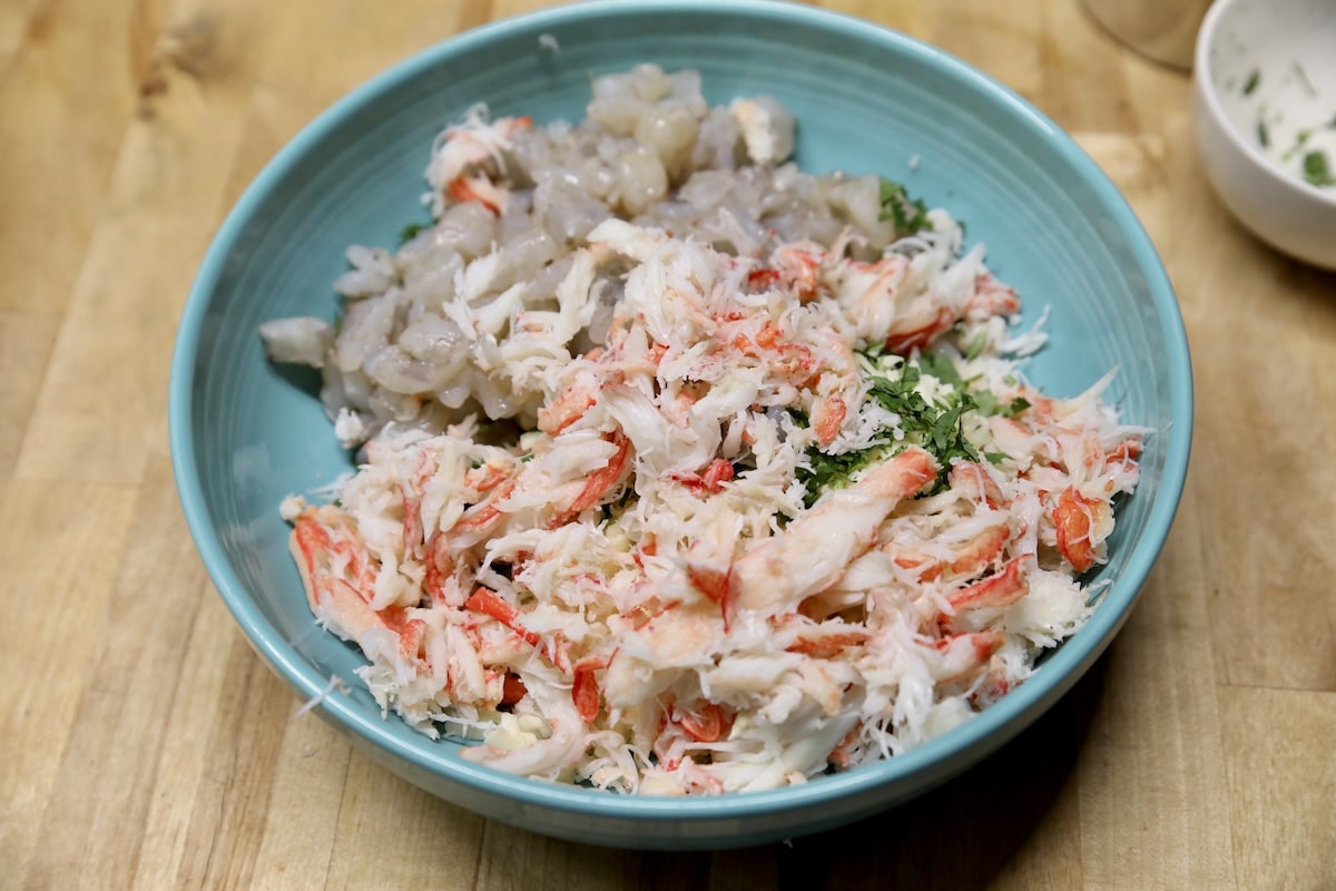 Cheese, crab, shrimp, cilantro in a bowl.