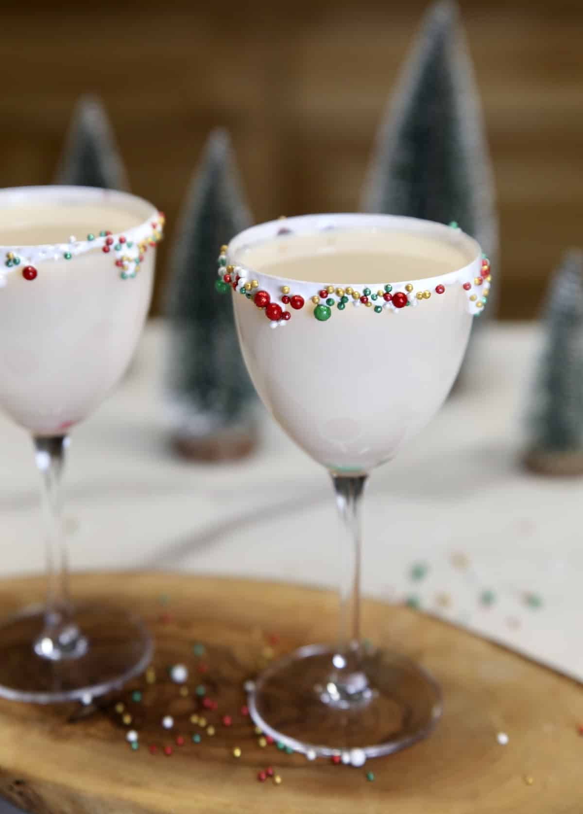 Christmas cocktail with sprinkle garnish. Sugar cookie cocktails in coupe glasses - sprinkle rim garnish.
