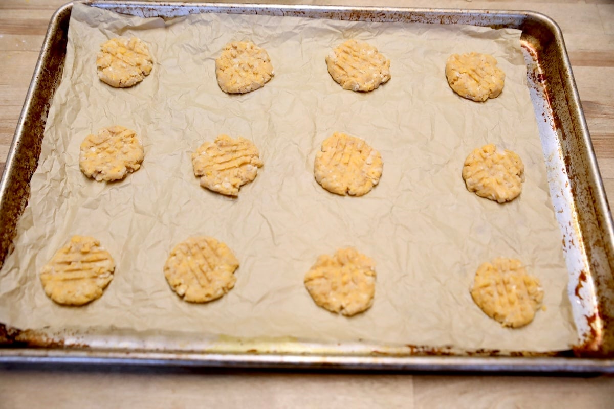 Sheet pan of smashed cheese wafers ready to bake.