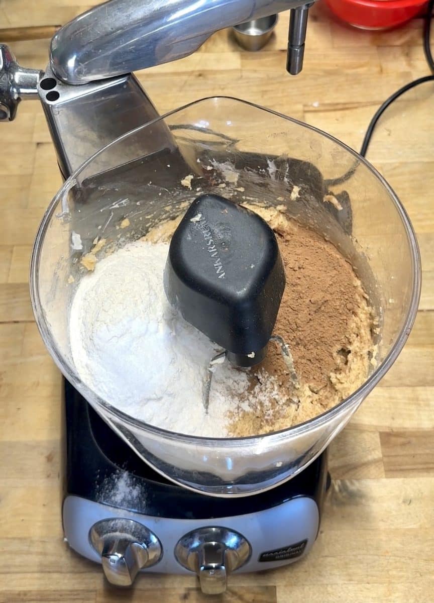 Mixer with cookie dough, flour and cocoa powder.