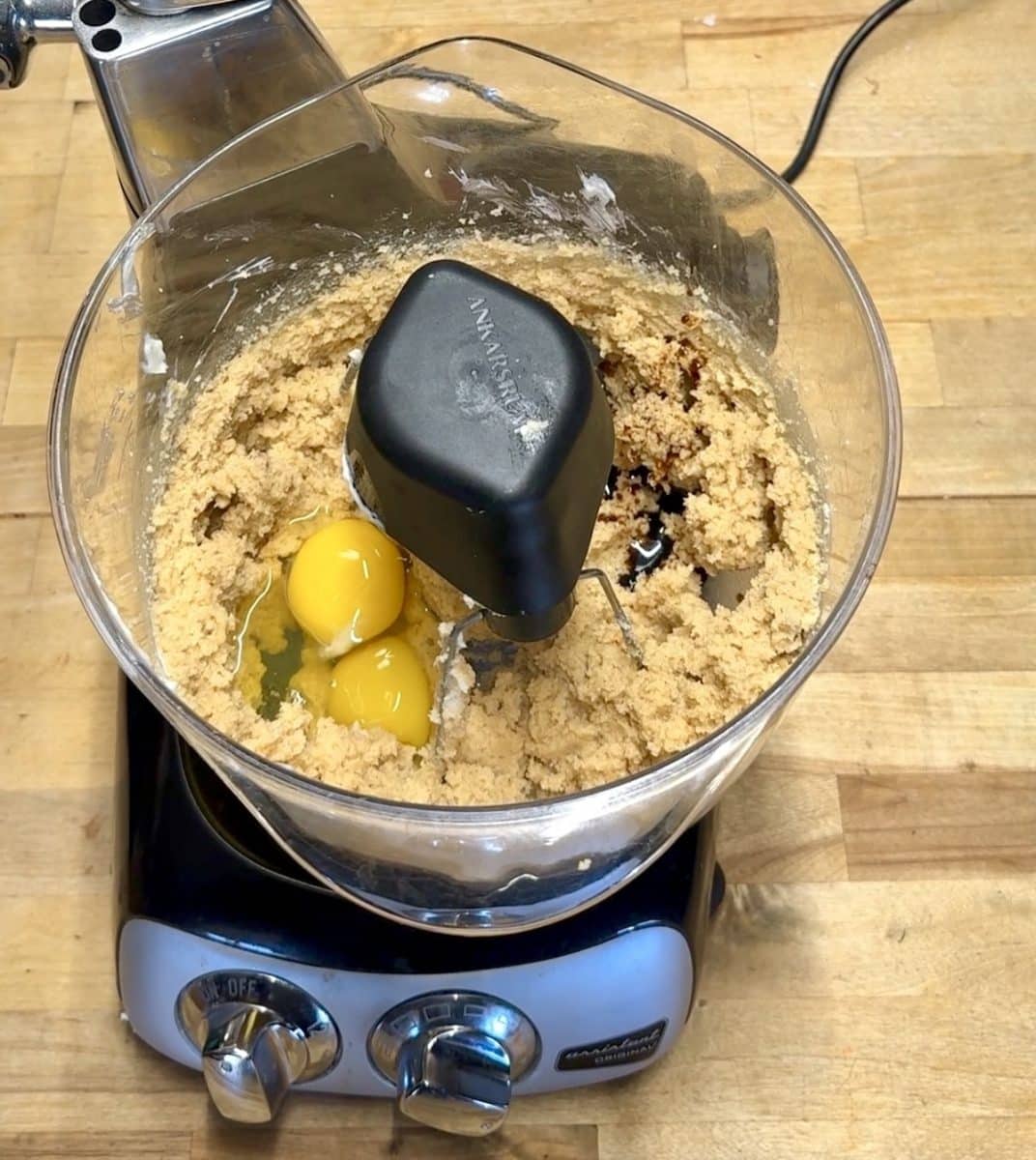 Cookie dough in a mixer with eggs and vanilla.