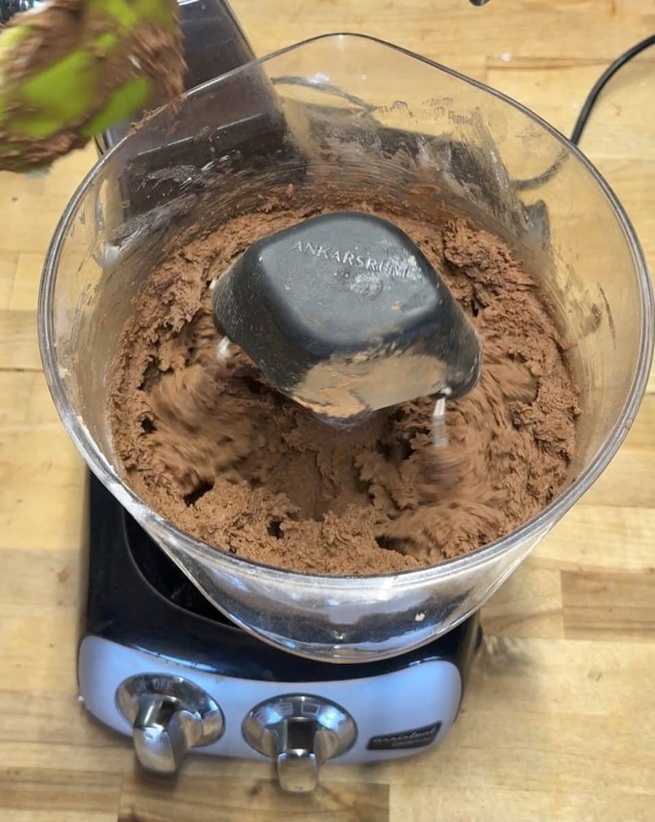 Chocolate cookie dough in a mixer.