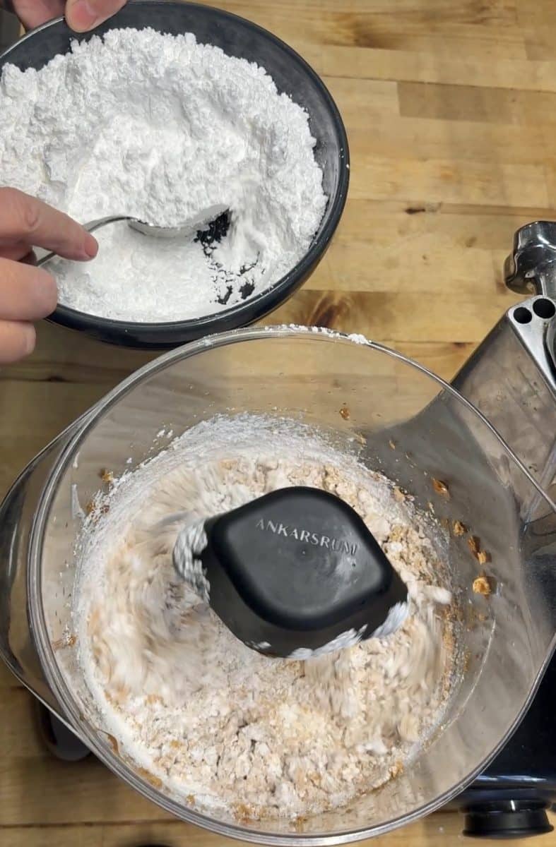 Adding powdered sugar to mixer bowl for frosting.