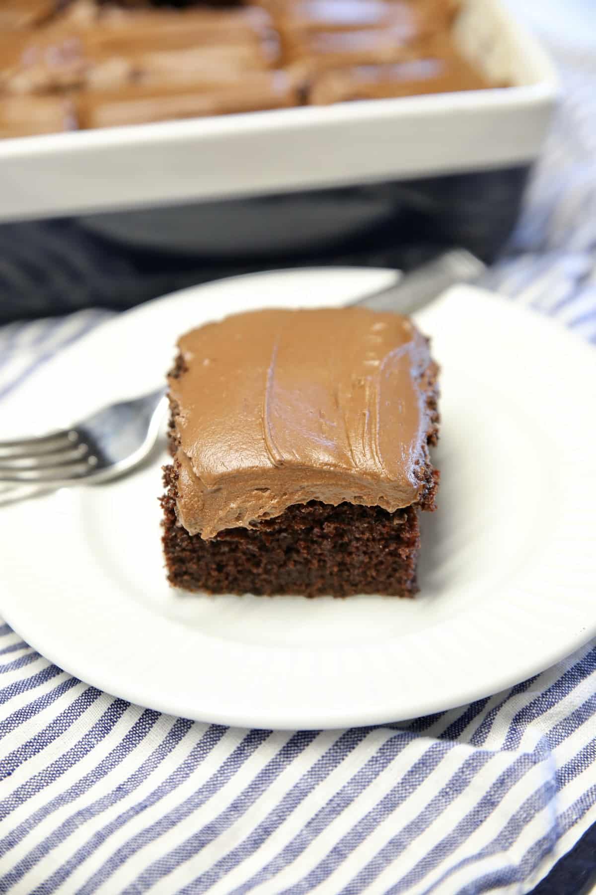 Chocolate cake slice on a plate with fork.
