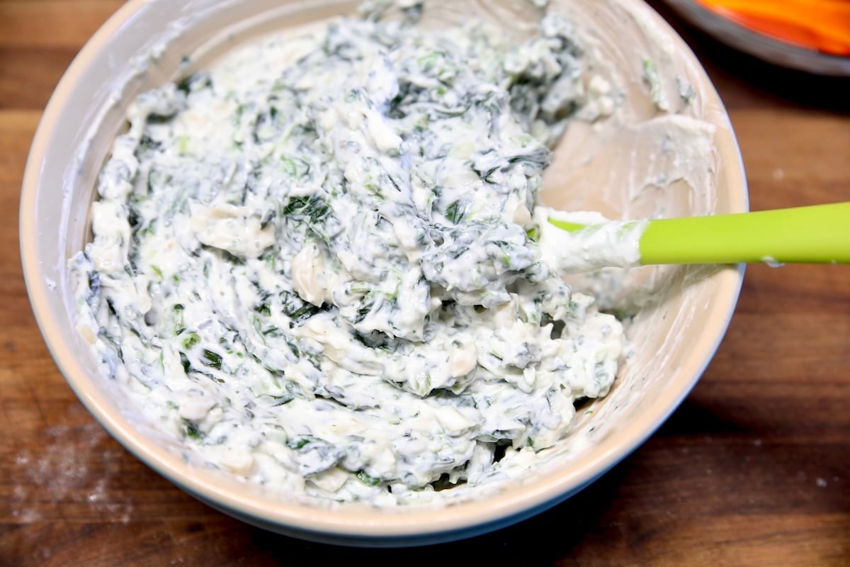 Spinach dip with spatula in a bowl.