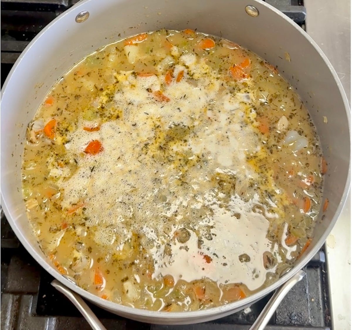 Adding cream to seafood chowder.