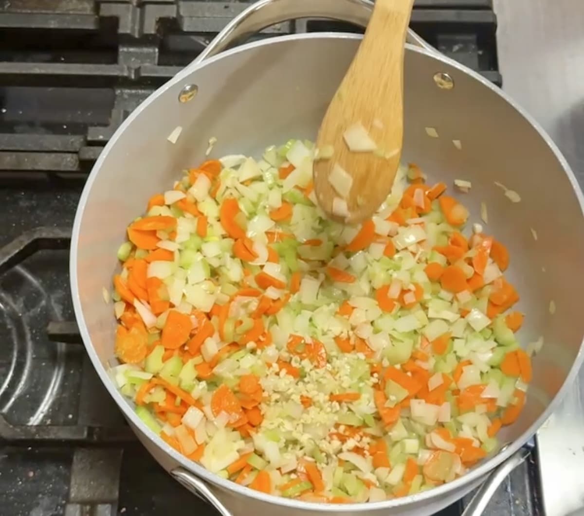 Cooking vegetables in a pan: carrots, onions, celery.
