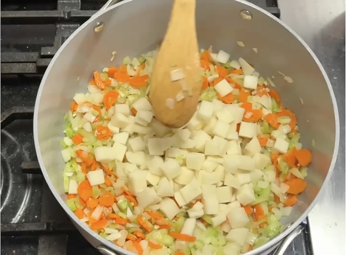 Cooking chowder vegetables in a pan.