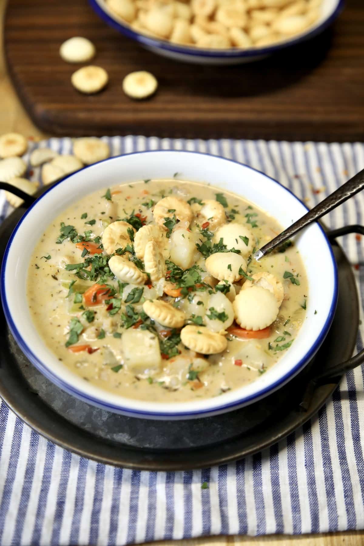 Bowl of seafood chowder with oyster crackers.