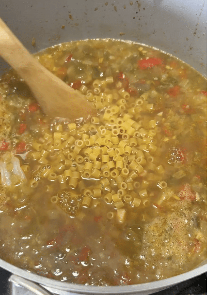 Adding pasta to soup.
