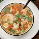Seafood soup in a bowl with shrimp, clams, crab.