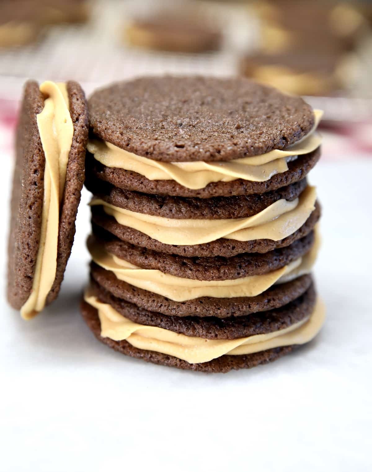 Stack of chocolate sandwich cookies with caramel icing.
