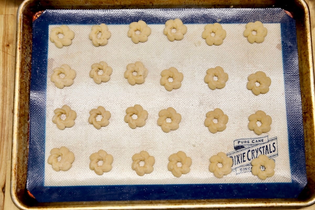 Spritz cookies on a baking sheet.