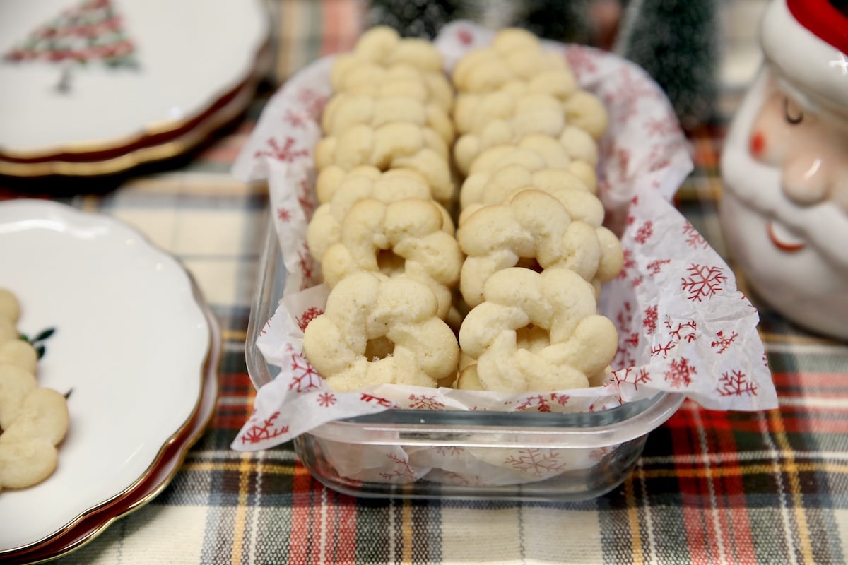 Easy spritz cookies. Bowl of spritz cookies on a Christmas plaid cloth.