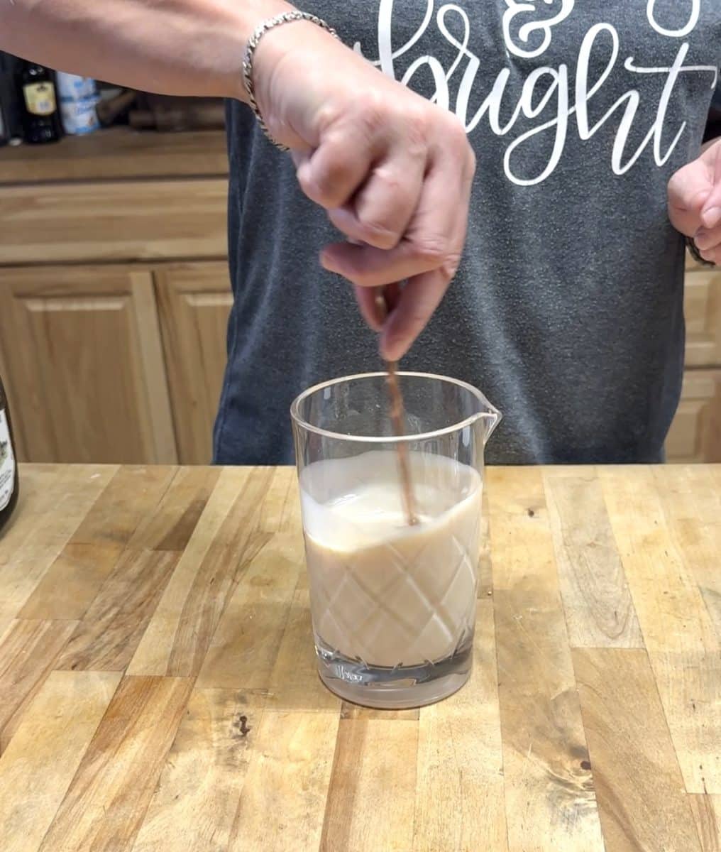 Mixing sugar cookie cocktail in a glass.