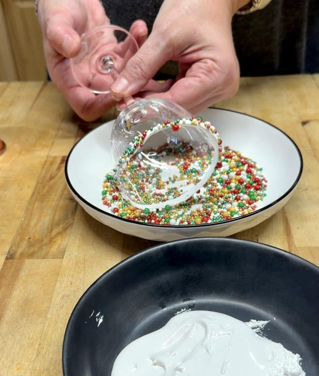 Rolling a glass in sprinkles.