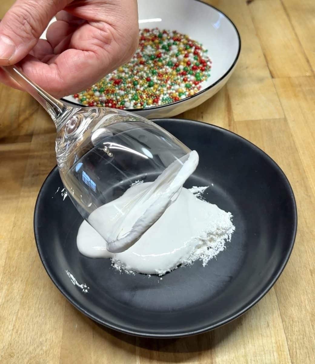 Rolling rim of glass in marshmallow creme.
