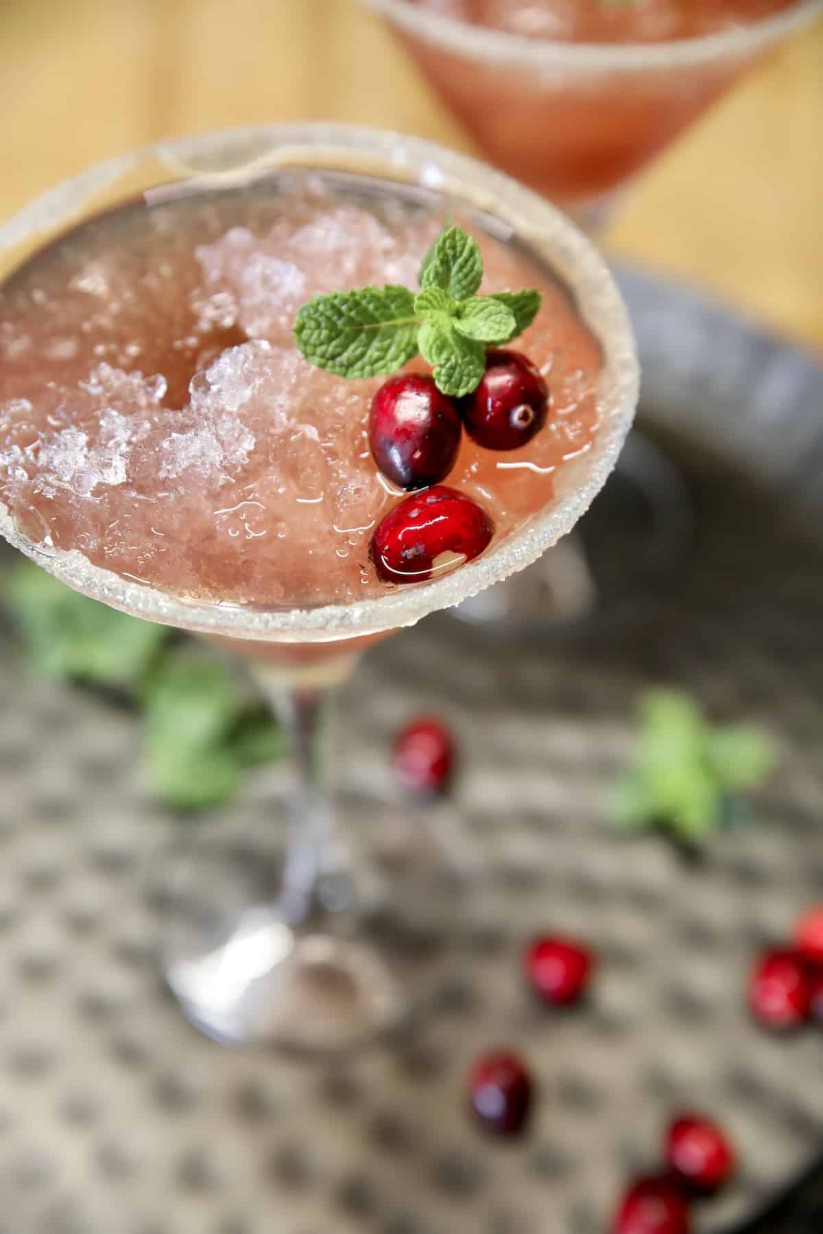 Tipsy Reindeer Cranberry cocktail in a martini glass with cranberry garnish.