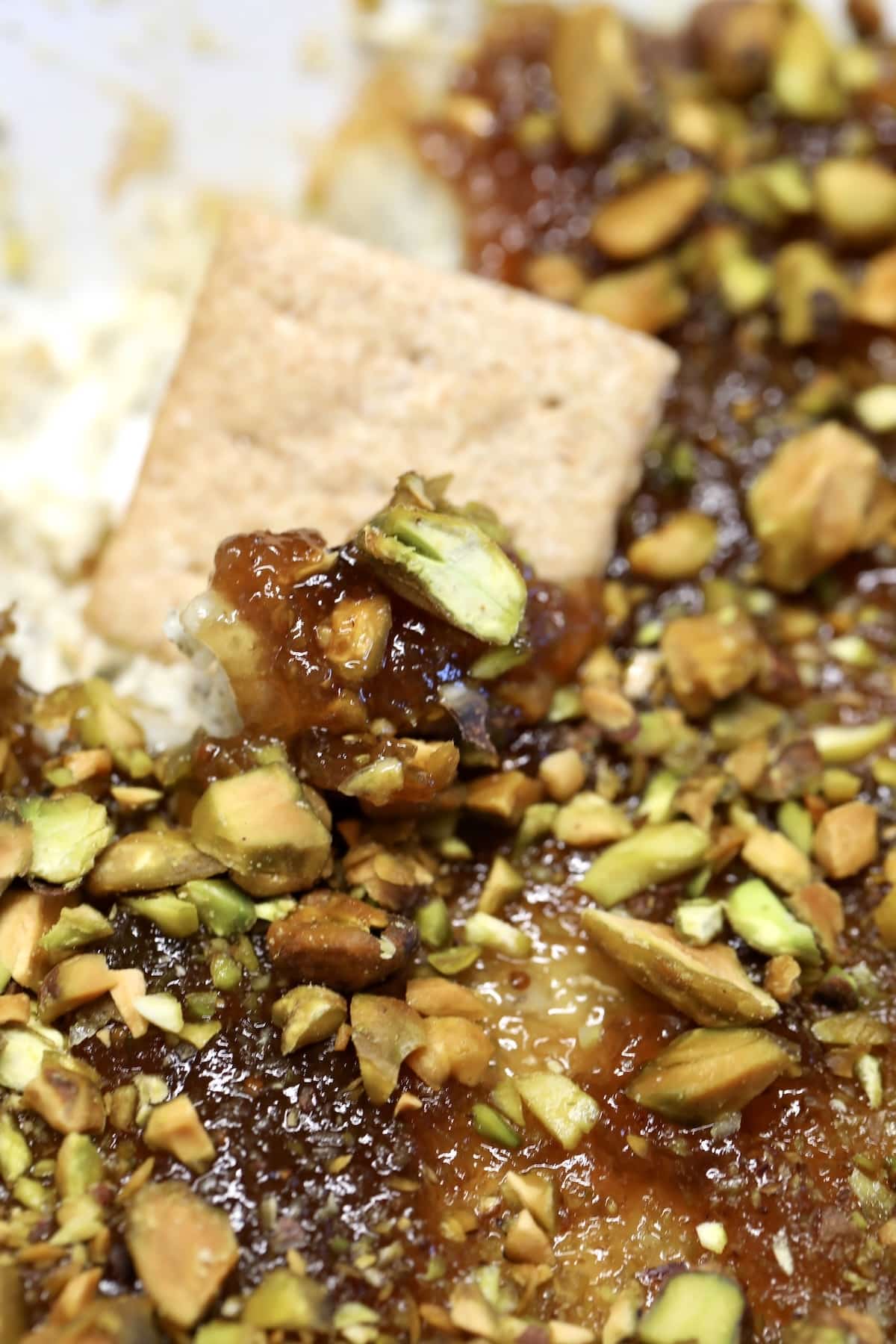 Cracker dipping into fig an boursin dip.