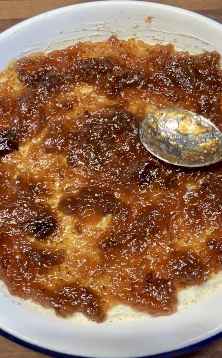 Spreading fig jam over garlic and herb cheese.