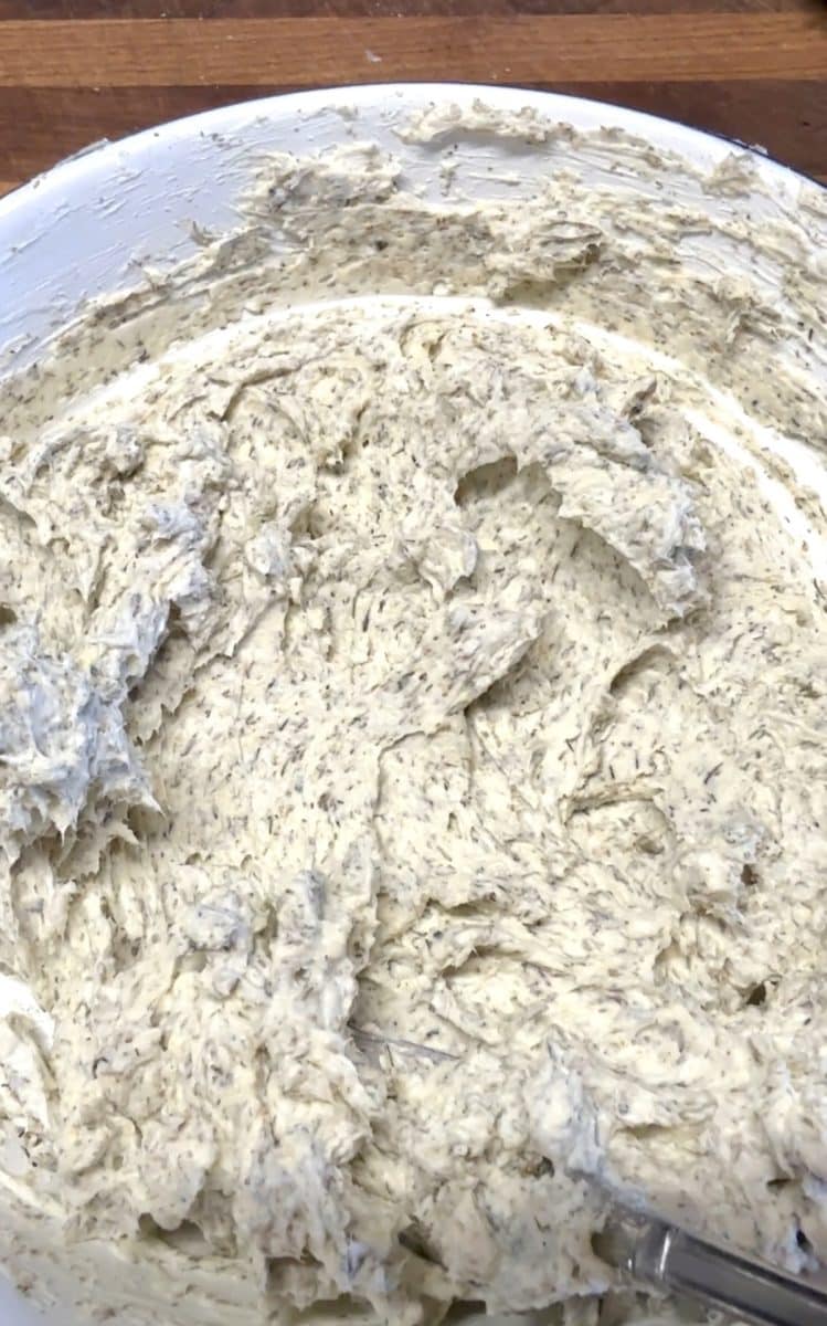Bowl of whipped cream cheese with garlic and herbs.