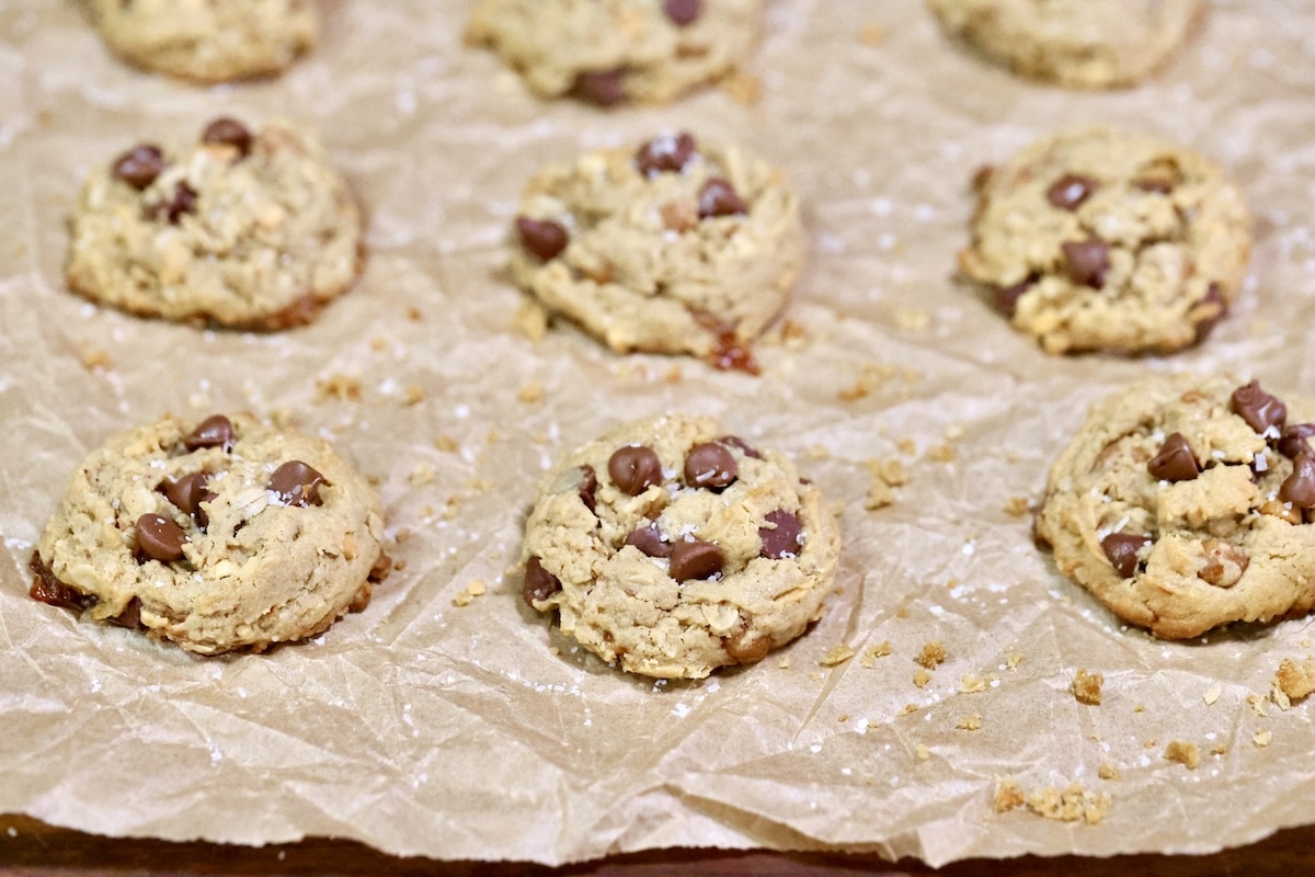 Chocolate chip cookies on a parchment lined baking sheet.