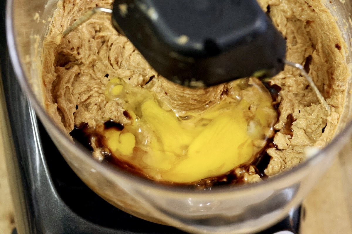 Mixer bowl with cookie dough, eggs, vanilla.