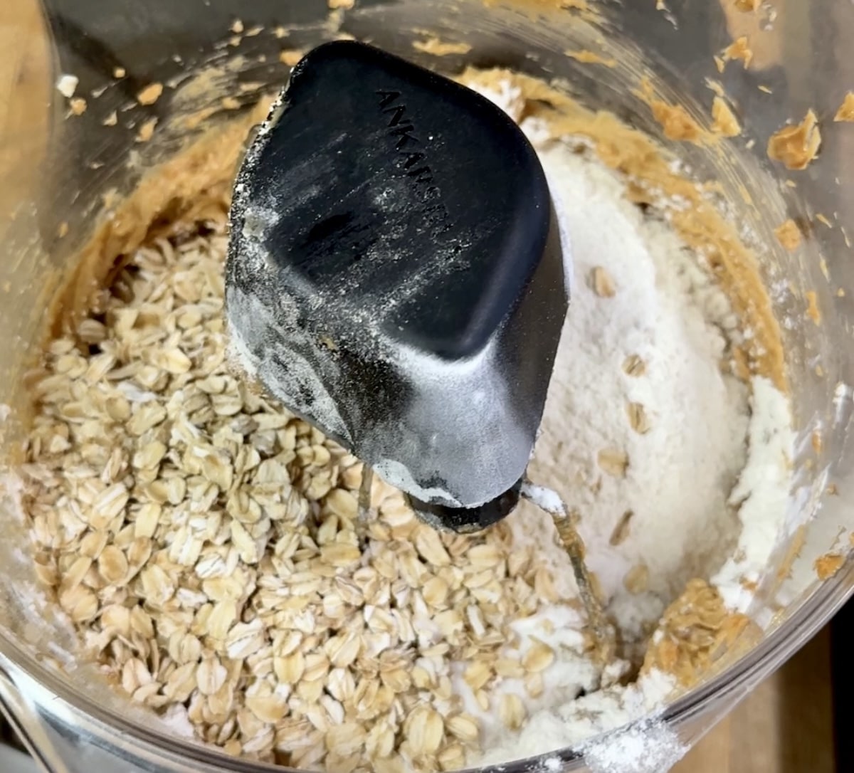 Mixing oats and flour into cookie dough.