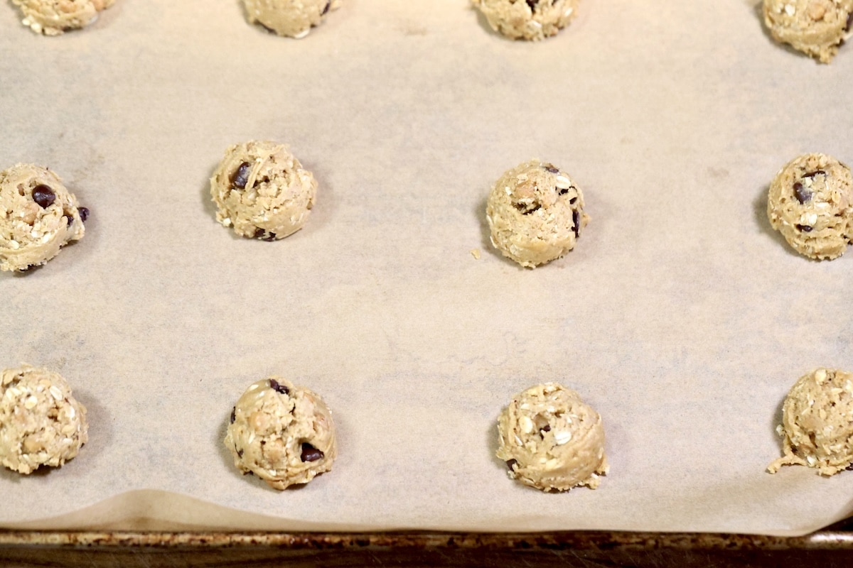 Cookie dough on parchment lined baking sheet.