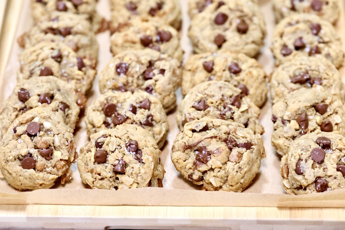 Oatmeal cookies loaded with crunchy peanut butter, oats, chocolate chips and caramel. Tray of loaded peanut butter oatmeal cookies.