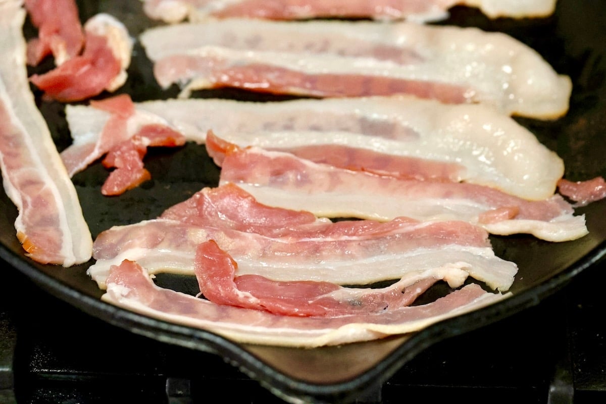 Sliced bacon in a skillet.