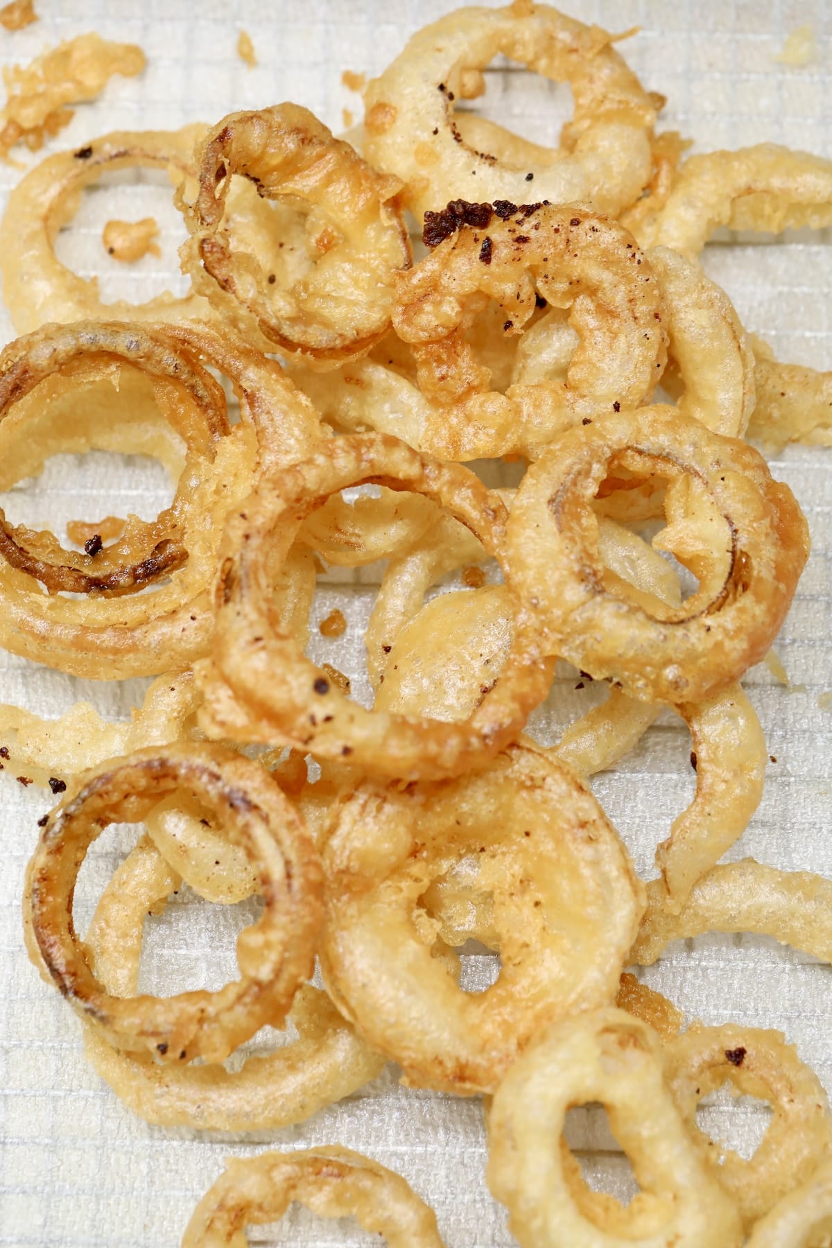 Fried onion rings on a paper towel.