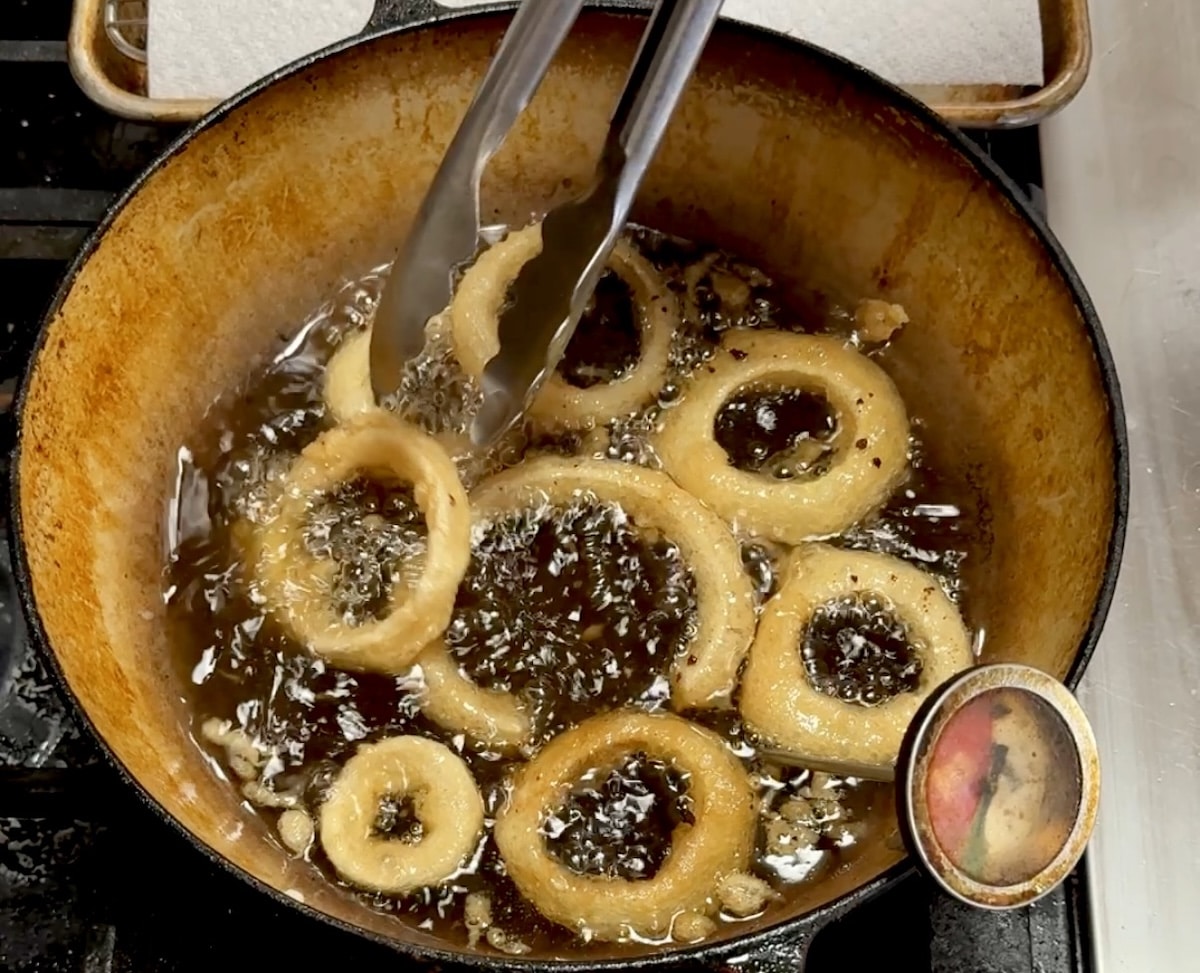 Frying beer batter onion rings.