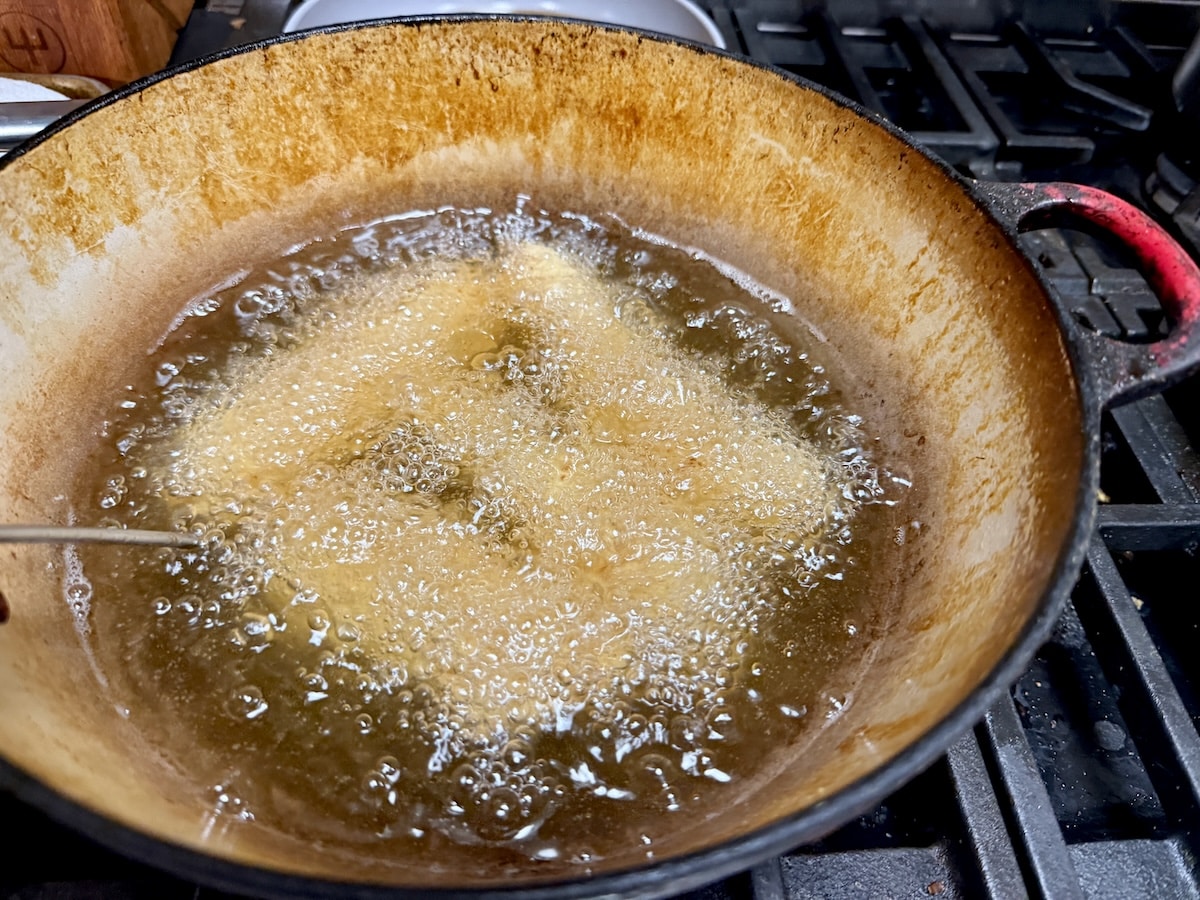 Frying chicken strips in a pan.