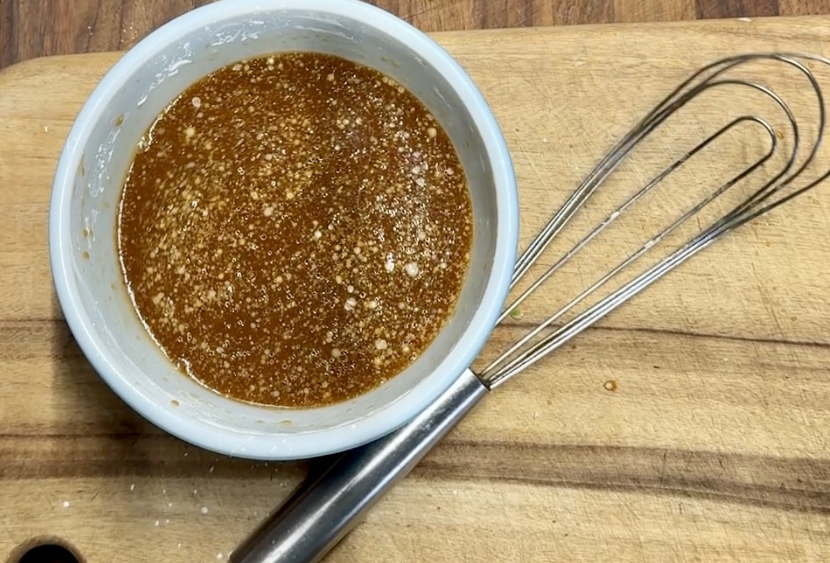 Bowl of sesame sauce with whisk.