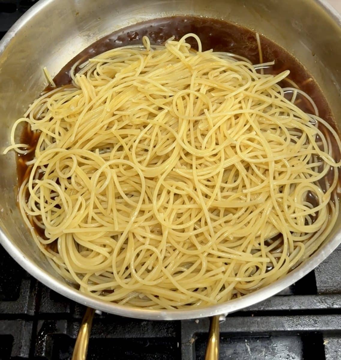 Spaghetti in a pan with sesame sauce.