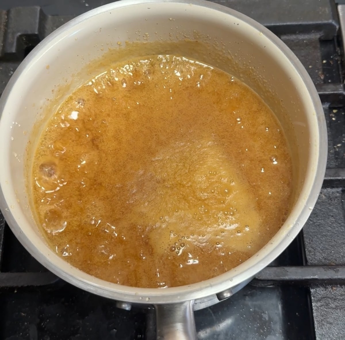 Pan of orange sauce, bubbling.