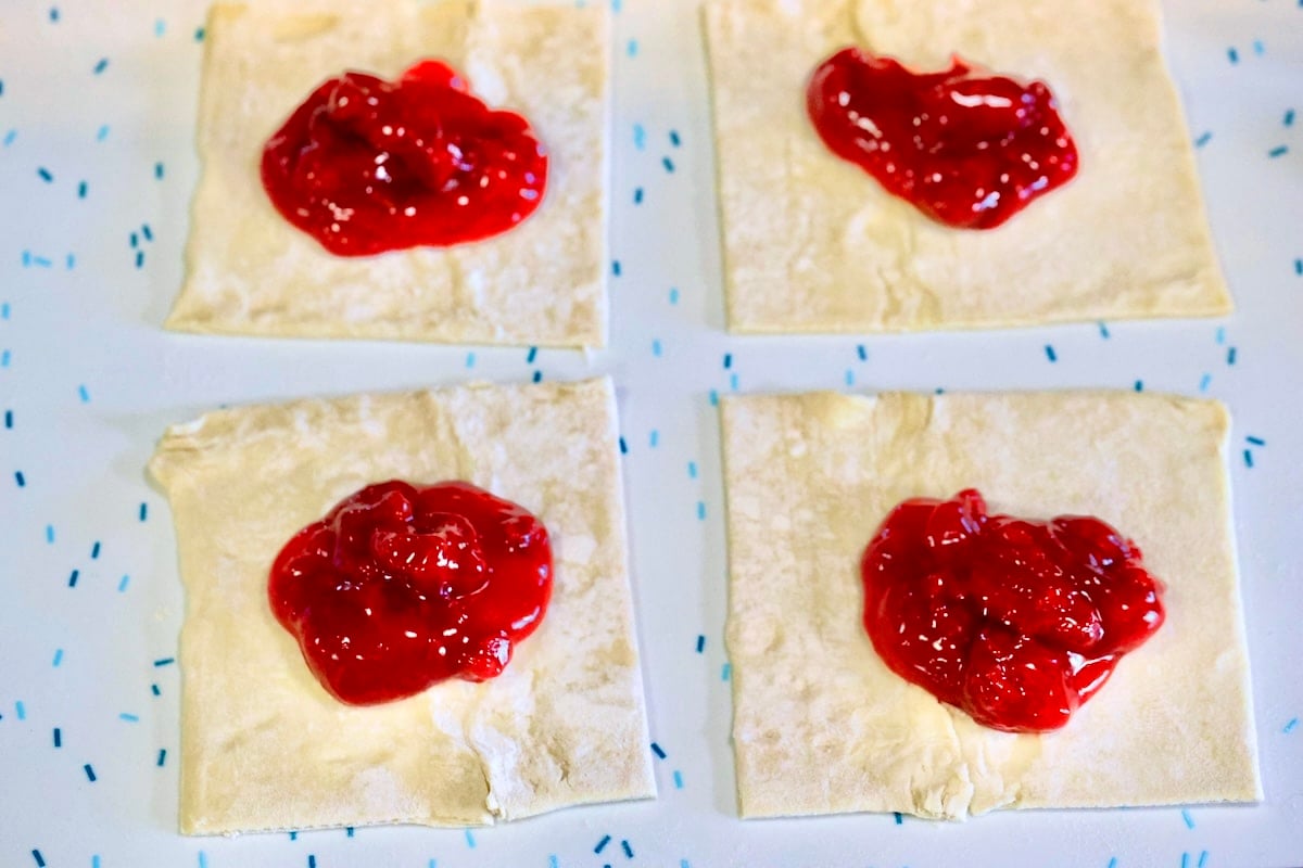 Strawberry pie filling over puff pastry squares.
