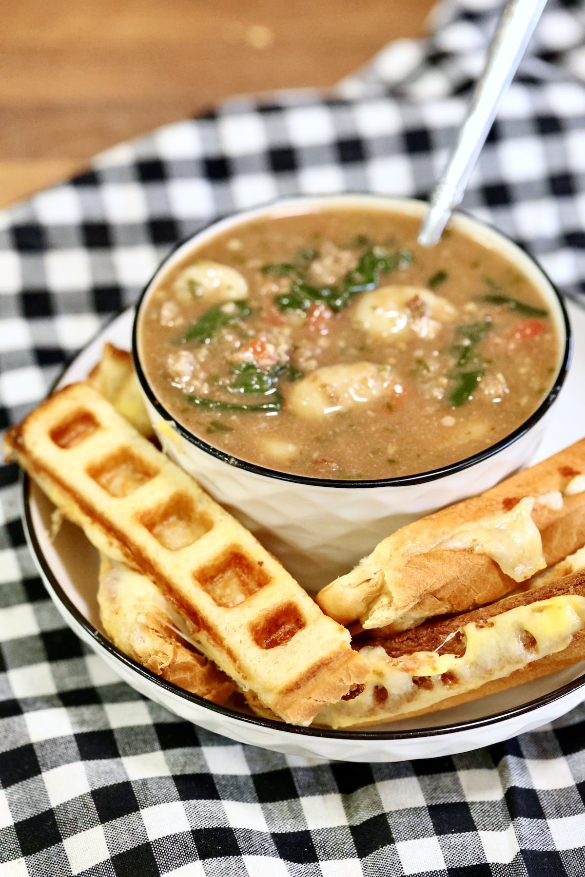 Waffle iron grilled cheese with bowl of gnocchi soup.