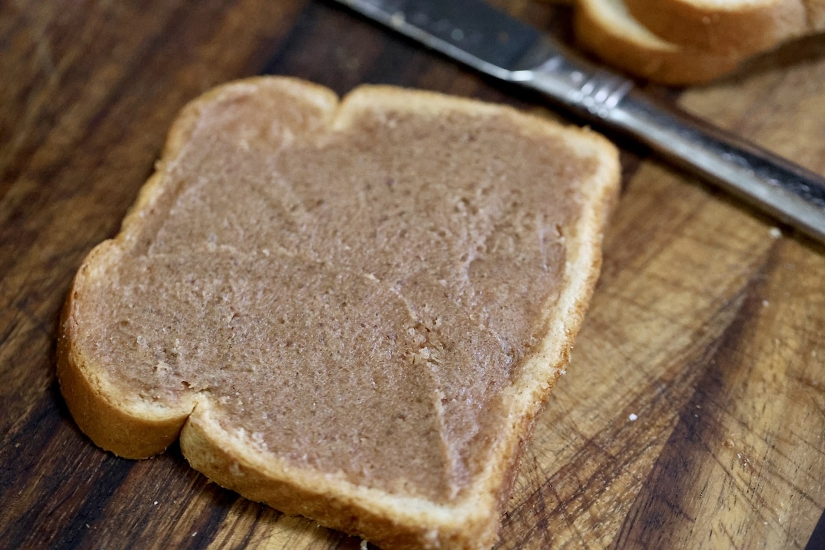 Brown sugar cinnamon and butter mixture spread onto a slice of bread.