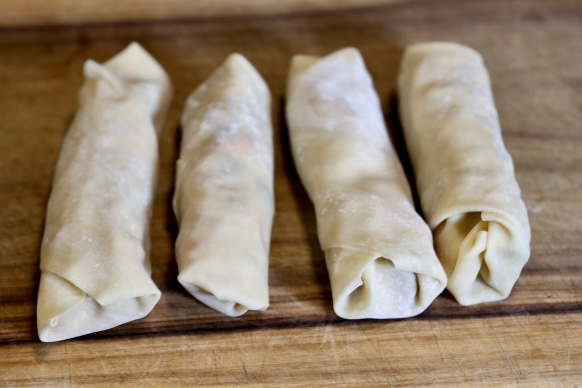4 Egg rolls on a cutting board.