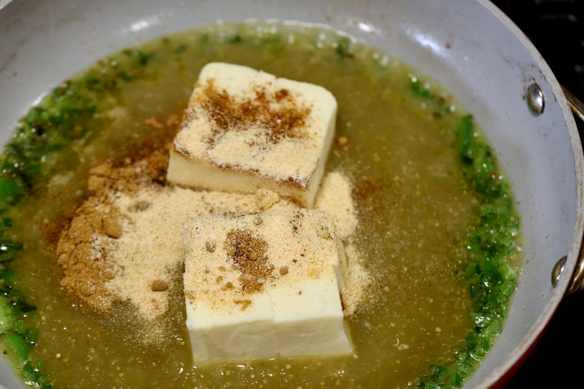 Salsa verde, jalapeno and white Velveeta cheese in a pan for queso.