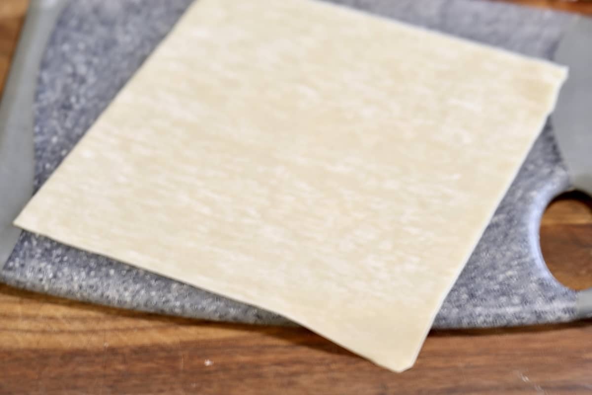 Egg roll wrapper on a cutting board.