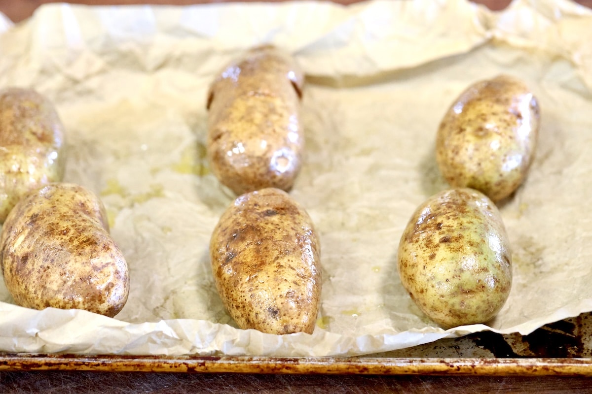 Russet potatoes on a baking sheet.