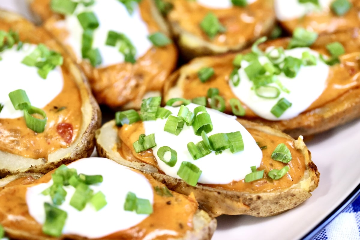Chili cheese loaded potato skins with sour cream and green onions.