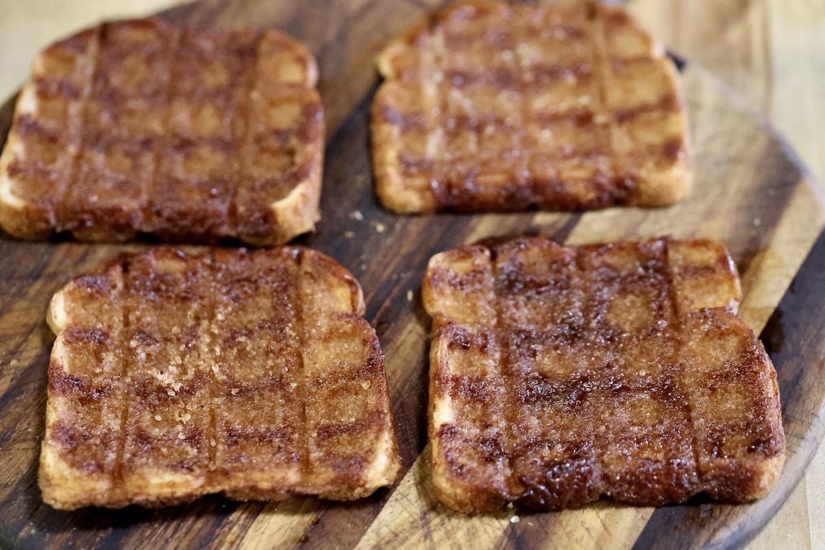 4 Cinnamon toast waffles on a cutting board.