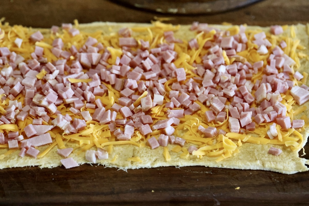 Chopped ham and cheese on crescent dough rectangle.